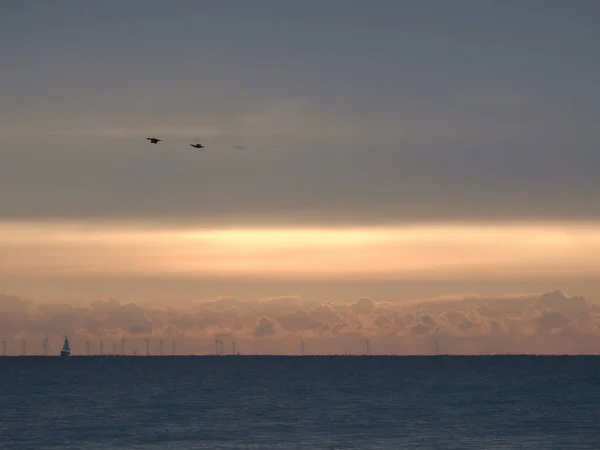 Alba Sul Mare Con Una Piccola Barca Vela Visibile Lontananza — Foto Stock