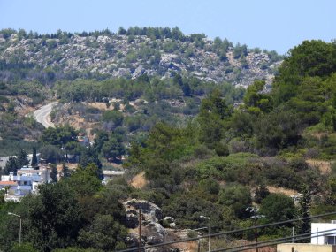 Ağaçları ve binaları olan kuru dağlık alanların manzarası