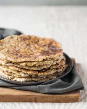 Ev yapımı tam buğday unlu tortilla yığını keten masa örtüsü üzerinde, seçici odaklı.