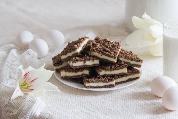 Delicious layered chokolate cocoa cake bars with cottage cheese feeling on white plate, selective focus