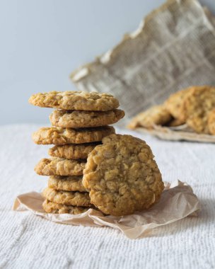 Hafif arka planda mısır gevreği olan bir yığın lezzetli yulaf ezmeli kurabiye.