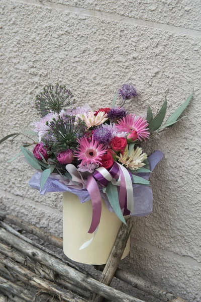 Beautiful summer bouquet in round box. Arrangement with various flowers. The concept of a flower shop.