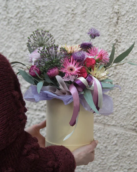 Beautiful summer bouquet in round box. Arrangement with various flowers. The concept of a flower shop.