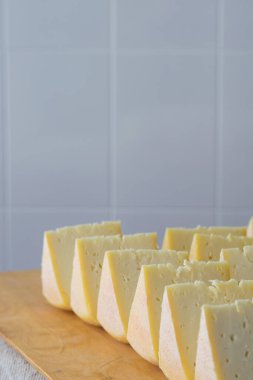 Tahtadaki peynir parçaları, seçici odaklanma. Keçi peyniri, uzun zamandır olgunlaşmış zanaat peyniri.