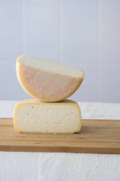 薄い背景に木製のボード上の丸いパルメザンチーズやペコリーノチーズの頭をカット 新鮮な乳製品 健康的な有機食品 選択的な焦点 コピースペース おいしい前菜 — ストック写真