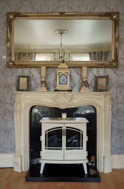 Ev oturma odasında dekoratif Gürcü şöminesi ve lonca aynası.