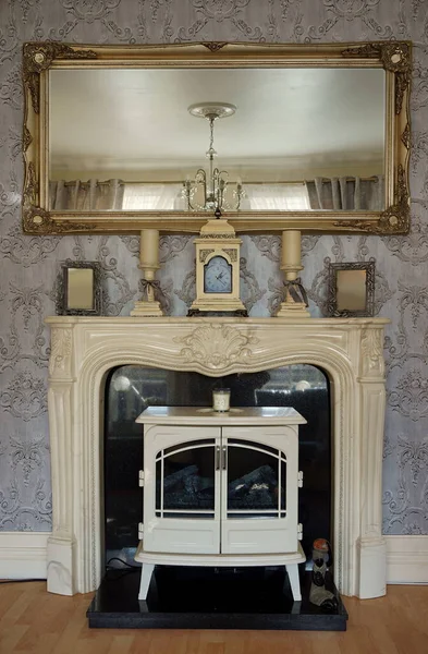 Ev oturma odasında dekoratif Gürcü şöminesi ve lonca aynası.