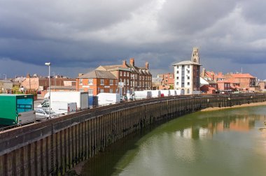 Gökyüzünde kara bulutlar olan beyaz minibüsler High Street 'te park halindeydi. River Haven / Witham önde. Boston Lincoln Bölgesi İngiltere
