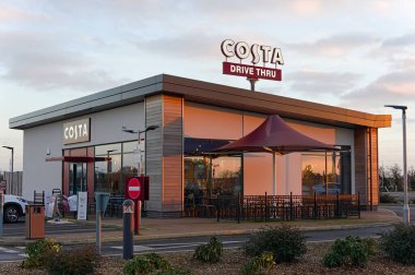 Wyberton 'daki yeni çeyreğin bir kısmında gün batımında bir COSTA sürücüsü. BOSTON Hughnshire,  