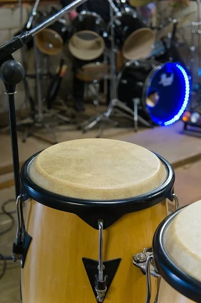 Traditional bongo drum with drum kit defocused in background