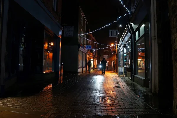 An almost deserted alleyway in the rain at night during christmas