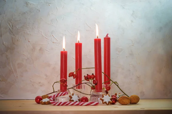 圣诞节前的第三个星期天 点燃了四支红色的蜡烛 三支在一张木桌上 复制的空间 选定的焦点 狭窄的田野深度 — 图库照片