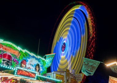 Molln, Almanya, 06 Kasım 2021: Hızlı sürüş ve aydınlatma tezgahları, renkli soyut eğlence arka planı, fotokopi alanı, hareket bulanıklığı ile yıllık gezici eğlence fuarına uzun süre maruz kalma
