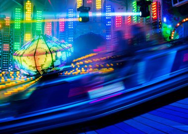 Hızlı sürüş ışık izleri, yıllık gezici eğlence fuarı, renkli soyut eğlence arka planı, kopyalama alanı, hareket bulanıklığı üzerine uzun pozlu çekim.