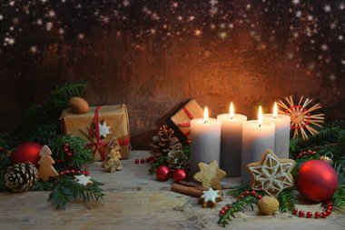 Dördüncü Advent, dört mum yakıldı, noel süslemesi ve kırsal ahşap kalaslarda hediyeler fotokopi alanı ile koyu kahverengi arka plan, seçili odak, dar alan derinliği