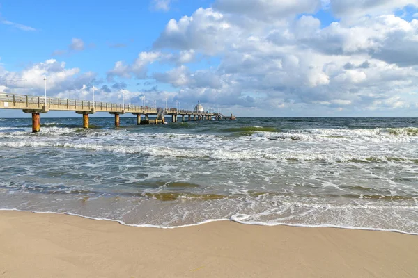 ドイツのバルト海の観光リゾートZinnowitzのビーチでのシーブリッジと波 コピースペース 選択されたフォーカスを持つ風の強い天気と青い空 — ストック写真