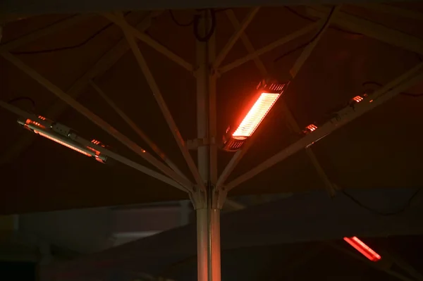 Geceleri Bir Sokak Kafesinde Şemsiye Altında Isıtma Lambaları Çünkü Kurallarına — Stok fotoğraf