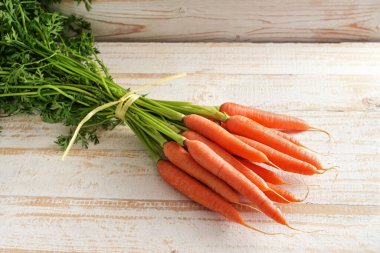 Bir sürü organik havuç. Pazardan taze yeşil. Kırsal bir masa üzerinde. Kopya alanı, seçilmiş odak, dar bir alan derinliği.