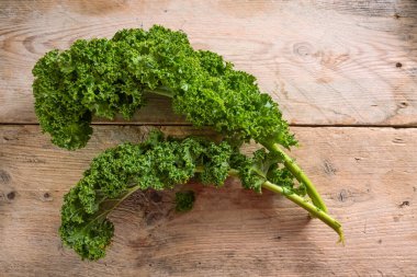 Kıvırcık lahana yaprakları ya da yeşil yaprak lahanaları, sade ahşap tahtalar, sağlıklı kış sebzeleri, kopya alanı, yukarıdan üst görünüm, seçilmiş odak noktası.