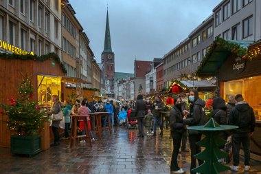 Lubeck, Almanya, 27 Kasım 2021: Koronavirüs salgınına rağmen birçok insan ve Noel tezgahlarıyla kalabalık içinde. Seçili odak
