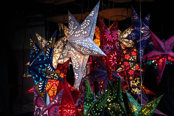 Parlayan Noel Yıldızları Kağıttan Katlanmış Farklı Renklerde Bir Pazar Yerinde — Stok fotoğraf