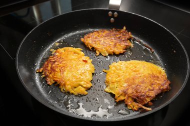 Siyah bir tavada kırmızı kuri kabağı ve patatesten kızartılmış gözleme, ayrıca kabak böreği, rosti veya patates, sebze sonbahar tarifi, kopya alanı seçili odak, dar alan derinliği olarak da bilinir. 