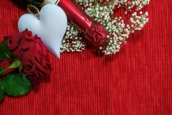 赤い生地の背景にシャンパンボトル ハートの形と花 バレンタインデーの愛のコンセプト コピースペース 上からの高い角度のビュー — ストック写真