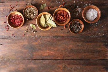 Kırsal bir masada küçük ahşap kaselerde çeşitli baharatlar, yemek ve yemek arka planı, büyük fotokopi alanı, yukarıdan yüksek açı manzarası.