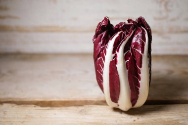 Radicchio Treviso ya da İtalyan hindiba, kırmızı yapraklı sebze kırsal bir ahşap masada duruyor, kopyalama alanı, seçilmiş odak, dar alan derinliği