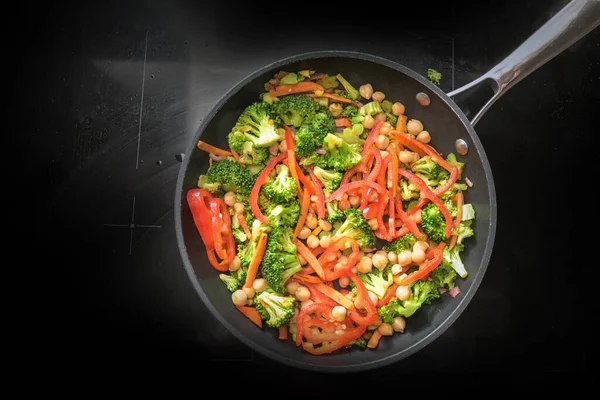 ブロッコリーと野菜パン 黒ストーブの上に赤ピーマンとひよこ豆 体重を減らすためにビーガン低炭水化物ダイエットのための健康的な料理 コピースペース 上から高い角度ビュー — ストック写真