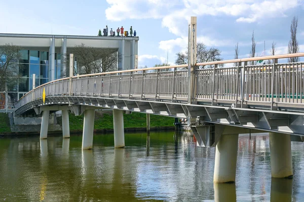 德国卢贝克的音乐与会议厅 Muk 的步行桥位于特拉夫河畔 由Meinhard Von Gerkan建造 屋顶上雕刻着 陌生人 的雕塑 蓝天布满了云彩 — 图库照片