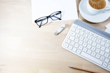 Bilgisayar klavyesi, kahve, usb çubuğu, gözlük ve kağıtlar evdeki iş için bir ahşap ofis masasında, kopyalama alanı, yukarıdan yüksek açı görünümü, seçili odaklanma