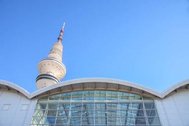 Hamburg, Germany, February 5, 2020: Television tower behind the modern building of the exhibition halls against a blue sky, copy space