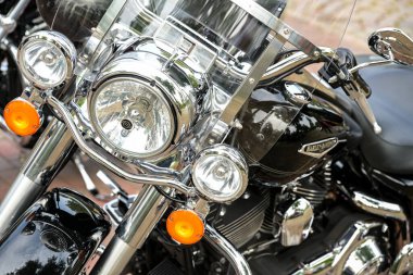 Ratzeburg, Germany, July 31, 2022: Part of a Harley Davidson motorcycle from the front with headlights, orange lamps and chrome, selected focus, narrow depth of field