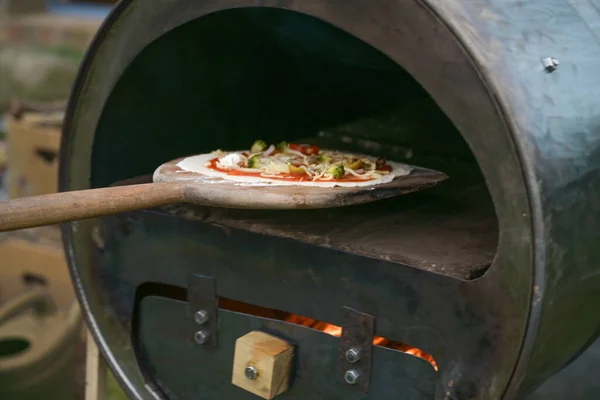 Świeża Pizza Drewnianym Szkiełku Jest Wpychana Samodzielnie Wykonanego Pieca Recyklingu — Zdjęcie stockowe