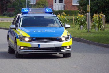 Varoşlardan birinde mavi ışıklar yanıp sönen Alman polis arabası. Polis, polis, kopyalama alanı, seçilmiş odak noktası anlamına geliyor.