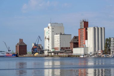 Flensburg, Almanya, 25 Temmuz 2022: Baltık Denizi 'ndeki Flensburg fiyortu üzerinde depolama binaları ve siloları olan sanayi şehri limanı, mavi gökyüzü, kopyalama alanı, seçilmiş odak noktası