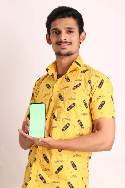 Wizerunek Nieogolonego Atrakcyjnego Indiańskiego Faceta Żółtej Koszuli Pokazującego Telefon Komórkowy — Zdjęcie stockowe