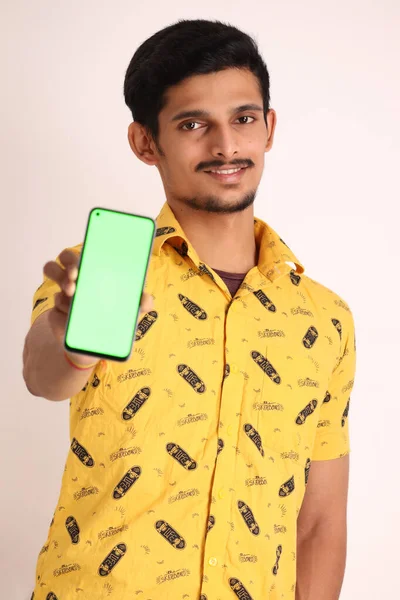 Wizerunek Nieogolonego Atrakcyjnego Indiańskiego Faceta Żółtej Koszuli Pokazującego Telefon Komórkowy — Zdjęcie stockowe