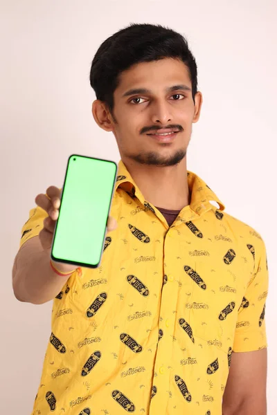 Зображення Має Привабливого Індійського Хлопця Жовтою Сорочкою Показуючи Мобільний Телефон — стокове фото