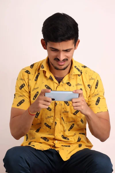 Nieogolony Atrakcyjny Indyjski Facet Żółtej Koszuli Gra Gry Smartfonie Android — Zdjęcie stockowe