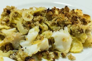 Ev yapımı morina balığı ve mısır ekmeği. Tipik bir Portekiz yemeği, doğranmış morina balığı, dilimlenmiş patates, soğan ve gevrek mısır ekmeği..