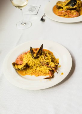 Geleneksel İspanyol deniz ürünleri paella 'sı restoran masasında yemeye hazır.