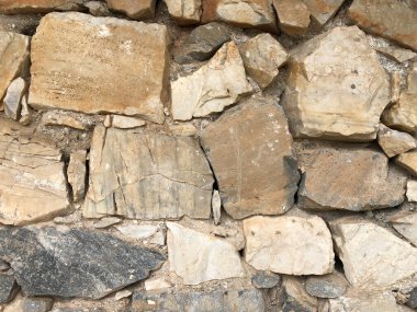 Soyut arka plan olarak farklı taşlara sahip eski antik bir duvar.