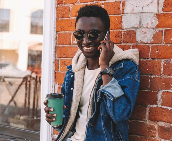 在城市街道上用智能手机交谈的快乐微笑的非洲男人的画像 — 图库照片