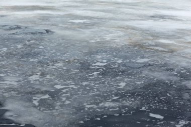 Donmuş bir denizde çatlamış buzlar, soğuk bir arka plan, havadan görünen su.