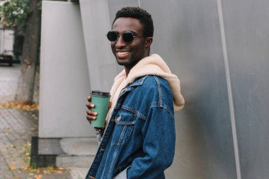 Şehirde kahve içen Afrikalı genç bir adamın portresi.