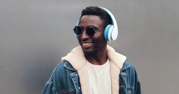 街の音楽を聴くワイヤレスヘッドフォンで幸せな笑顔のアフリカ人男性の肖像画のクローズアップ — ストック写真