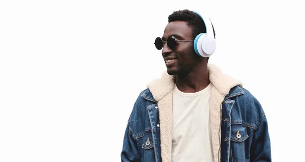 白い背景に孤立した音楽を聴くワイヤレスヘッドフォンで幸せな笑顔のアフリカ人男性の肖像画 — ストック写真
