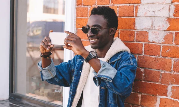 在城市街道上 年轻的非洲男子用智能手机自拍的快乐微笑的画像 — 图库照片